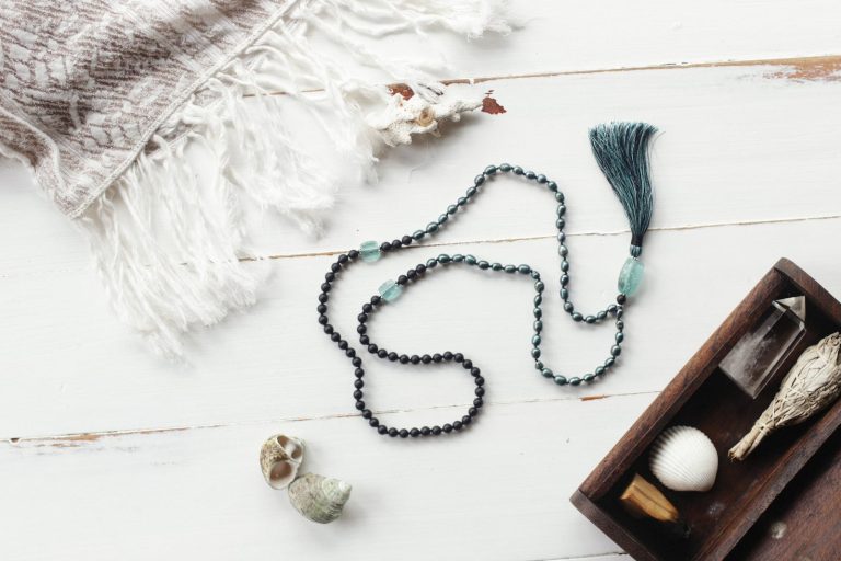 Green Beaded Necklace on White Wooden Surface